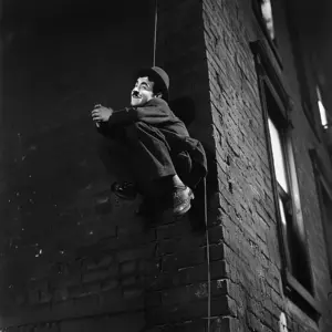 Charlie Chaplin schwebt vor einer Mauerwand