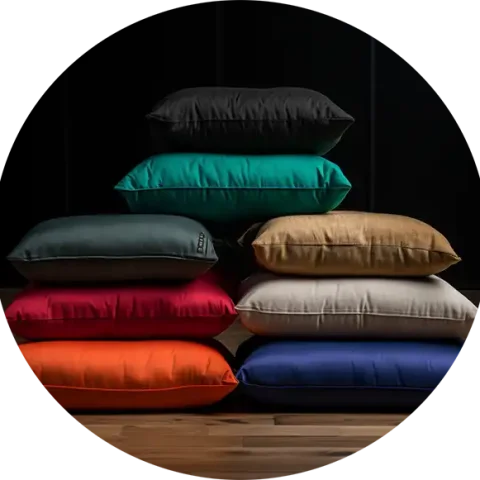 Sitzkissen für Yoga in verschiedenen Farben, aufeinandergestapelt in einem Yogaraum, man kann sie dort als Meditationskissen kaufen